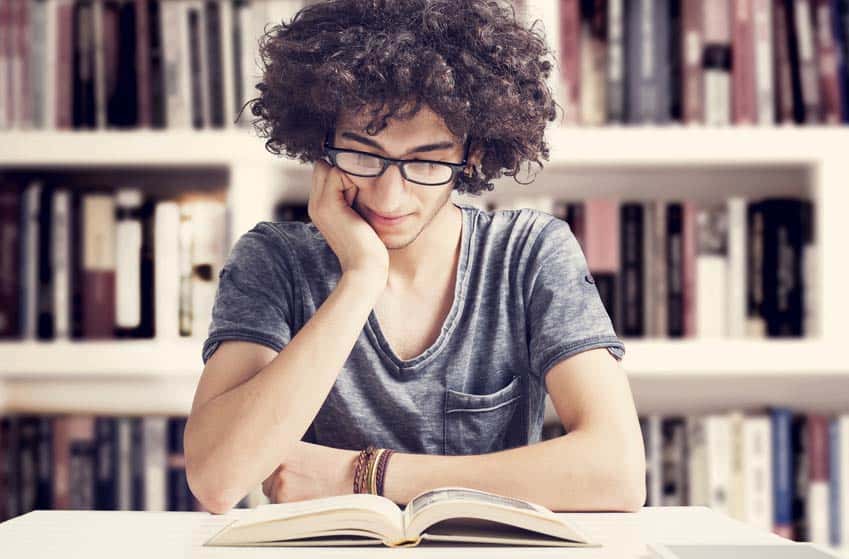 Young man reading a music book in the library