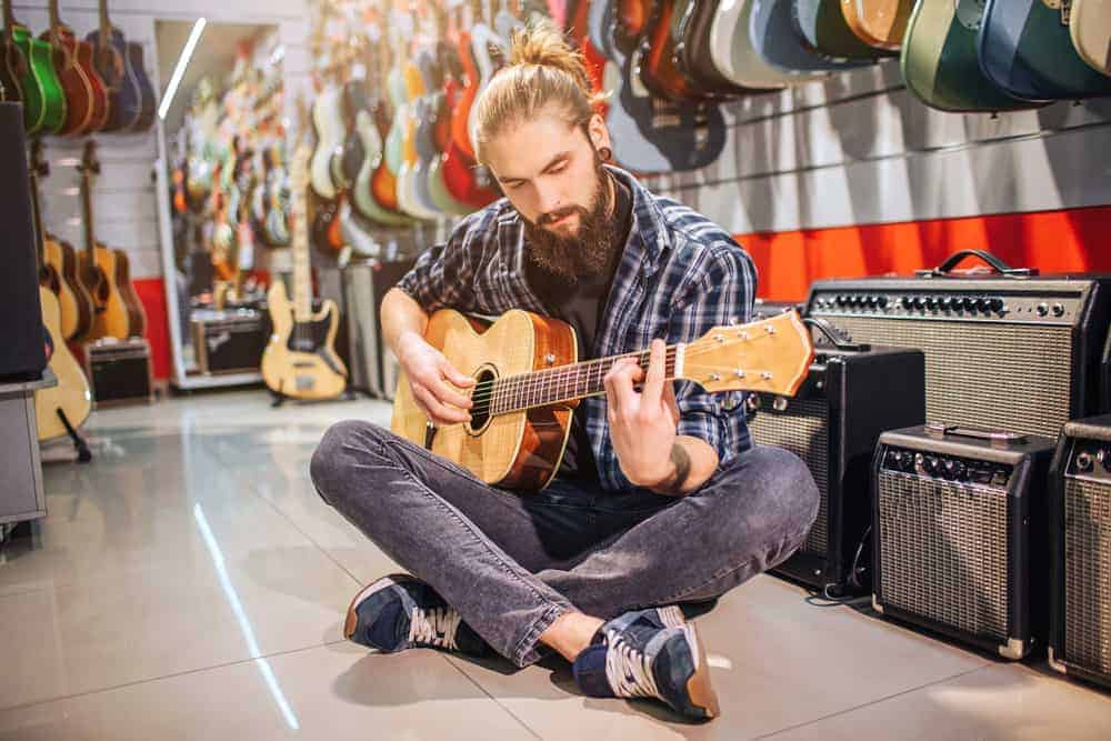 Man playing guitar at instrument store